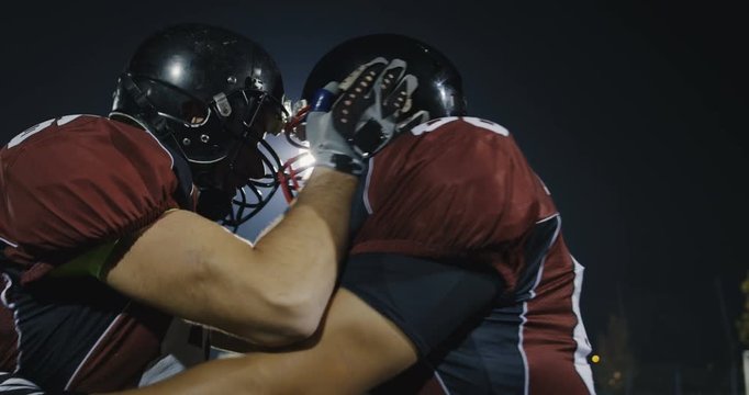 American football players knocking with helmets and having fun
