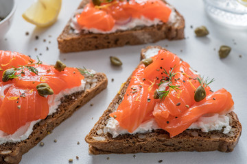 Smorrebrod, traditional Danish open sanwiches, dark rye bread with salmon, cream cheese and capers.