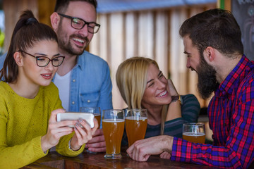 Friends in pub drinking beer having fun 