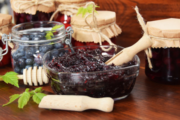 homemade blue marmalade with sugar and honey good for winter colds and jars full of raspberries in sweet syrup for tea for illness