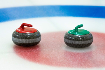 curling stones in the target on the ice