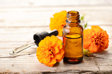 Tagetes essential oil and flowers on the wooden board