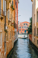Fototapeta na wymiar Narrow street-channels and gondolas with tourists in Venice, Italy