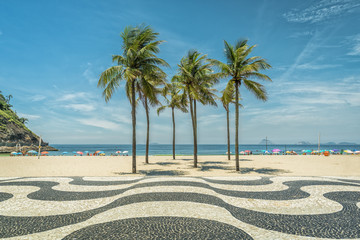 Palms on Copacabana Beach and landmark mosaic in Rio de Janeiro, Brazil. Sunny day with blue sky