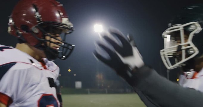 American football players knocking with helmets and having fun