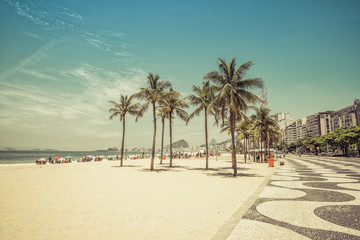 Sunny day on Copacabana Beach with palm trees in Rio de Janeiro, Brazil. Vintage colors