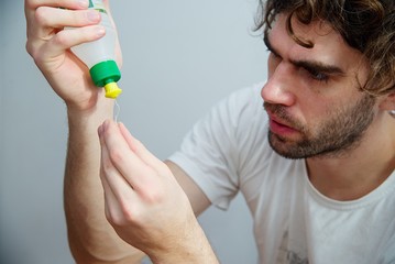 Man glue the broken plastic with glue. White skin, dark hair