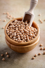 Raw organic chickpeas in a wooden bowl, healthy vegan vegetarian food ingredient.