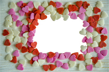 Hearts for photo frame...Colored hearts on a light wooden background. The middle of the photo is an isolate.