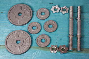 Top view of accessories for fitness in grey tone. Dumbbells, weight plates.