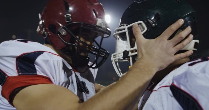 American football players knocking with helmets and having fun