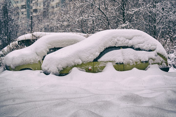 Old russian cars buried under a thick layer of snow