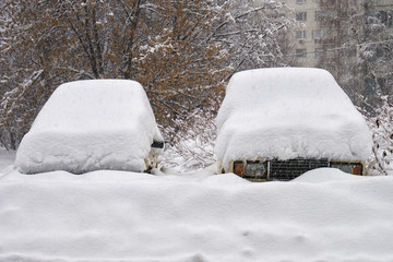 Old russian cars buried under a thick layer of snow