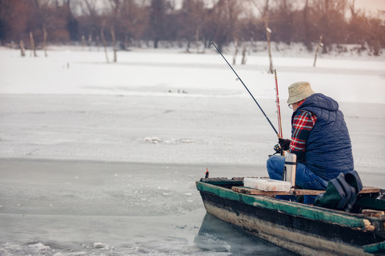 Winter season man fishing on frozen lake