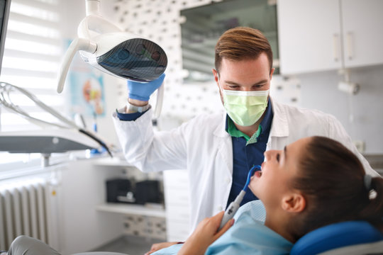 Dentist examining girl on clinic