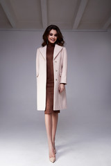 Beautiful sexy woman wear clothes for businesswoman office style casual dress cashmere wool coat grey background fashion catalog spring high heels lady perfect face and body makeup meeting jewelry.