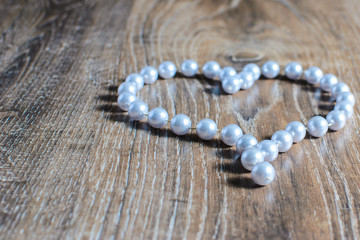 heart made of beads on a wooden background