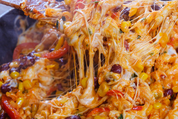 roasted vegetables, chicken and melted cheese for burritos close-up of cooking burrito food
