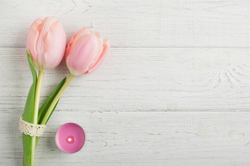 Pink tulip flowers, lit candle