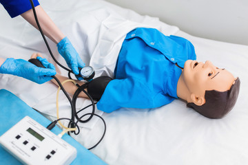 medical student measures blood pressure on a dummy. Training in medical practice in the training hospital