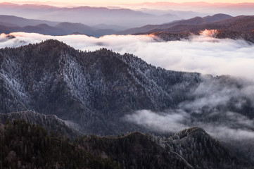 Obrazy na Szkle  Z punktu widokowego położonego wysoko w Parku Narodowym Great Smokey Mountains ciągnie się aż po horyzont linię grzbietów górskich. Jest wschód słońca, a niebo jest pomarańczowe. Niskie chmury wypełniają doliny. Mglisty i mglisty