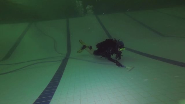 Garbage cleaning on the bottom of the Olympic pool. Dirty water in the sports pool. Hygiene of swimming in water, sanitary condition of water