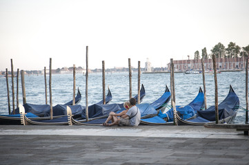 Obraz na płótnie Canvas Venice lagoon, Italy with gondolas and embraced couple