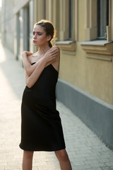 Fototapeta na wymiar Fashion model in summer dress pose on street sidewalk