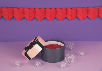 Pink gift box against ultra violet and lilac background.