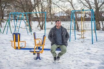 adult man sitting on a swing