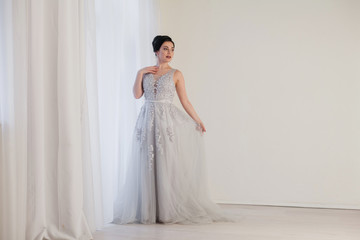 bride in wedding dress in white room