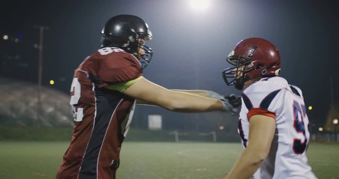 .Slow motion football players fight, engage and block