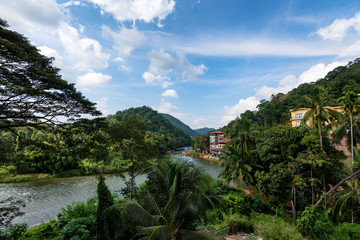 Tropical river view with wooden cottages on bank