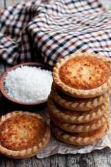 Stack  of coconut tarts on wooden table