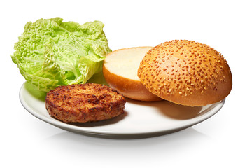 Hamburger, fresh bun with seeds and lettuce on white plate