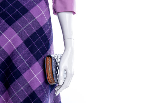 Close up mannequin in purple patterned skirt. Female mannequin with modern skirt and wallet close up, copy space. Brand clothes and accessories for ladies.