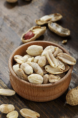 peanuts in a wooden plate on the table, a snack for beer.
