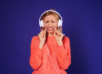 upset woman in headphones biting cord