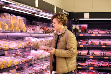 men purchasing a packet of meat at the supermarket 