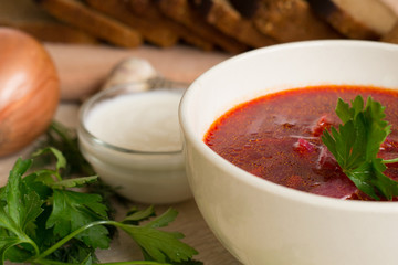 Borsch - beetroot soup in a clay bowl on a slate,stone or metal background,traditional dish of ukrainian cuisine.Top view.