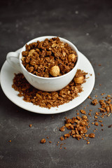 Granola in a white Cup on a black background. The concept of a healthy diet, weight loss, diet