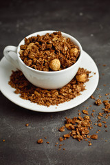 Granola in a white Cup on a black background. The concept of a healthy diet, weight loss, diet