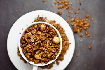 Granola in a white Cup on a black background. The concept of a healthy diet, weight loss, diet