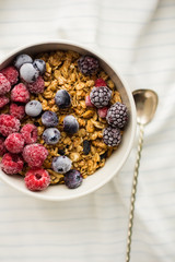 Granola on white wooden background with raspberry and blueberry berries. The concept of a healthy lifestyle, diet, healthy Breakfast