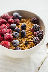 Granola on white wooden background with raspberry and blueberry berries. The concept of a healthy lifestyle, diet, healthy Breakfast