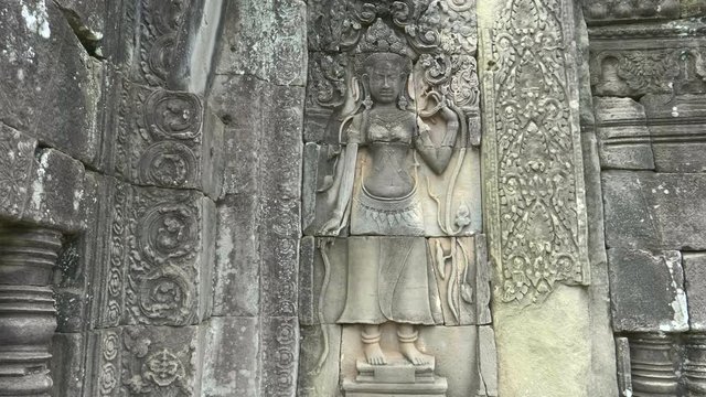tilt up shot of a beautiful devata bas relief carving at bayon temple near angkor wat, cambodia