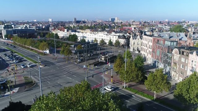 Aerial footage of intersection showing traffic driving over from all directions cars bicycles pedestrians furthermore showing tram stop and several commercial buildings in background 4k quality