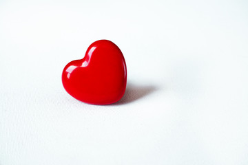 Red heart lying isolated on white surface