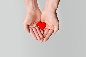 Red heart holding in male hands