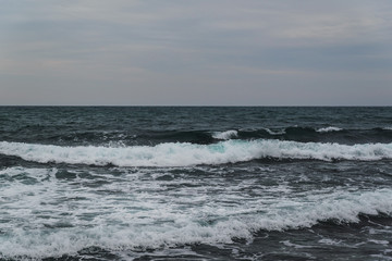 Storm on the sea in cloudy weather at sunset